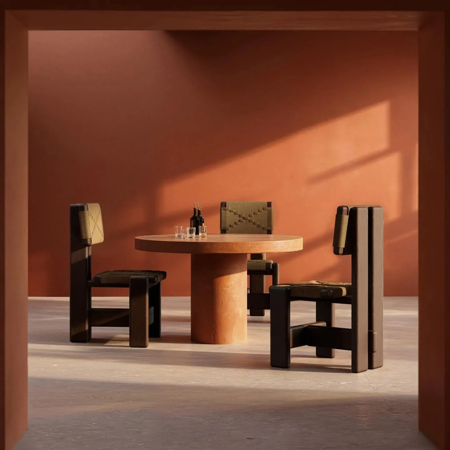 Round terracotta table with three dark wooden chairs in a terracotta room