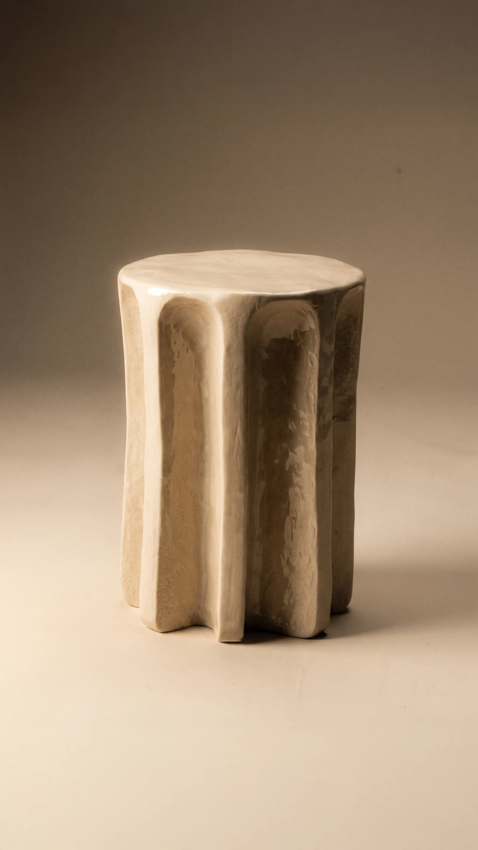 Cream glazed ceramic Chouchou side table with fluted sides on a warm backdrop